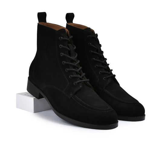 Black suede boots on a white background
