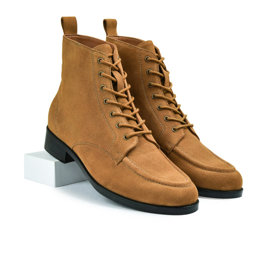 Pair of brown suede boots with black soles on a white background