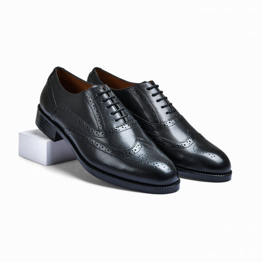 Pair of black leather dress shoes on a white background