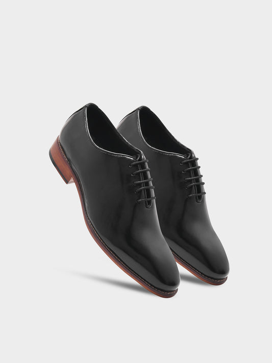 Pair of black dress shoes on a light gray background