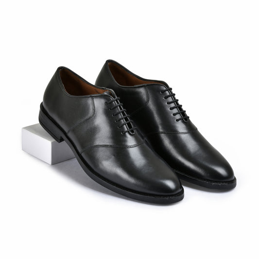 Pair of black leather dress shoes on a white background