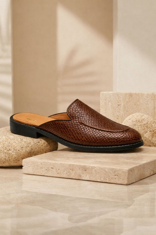 Brown leather slipper on a stone platform with a neutral background