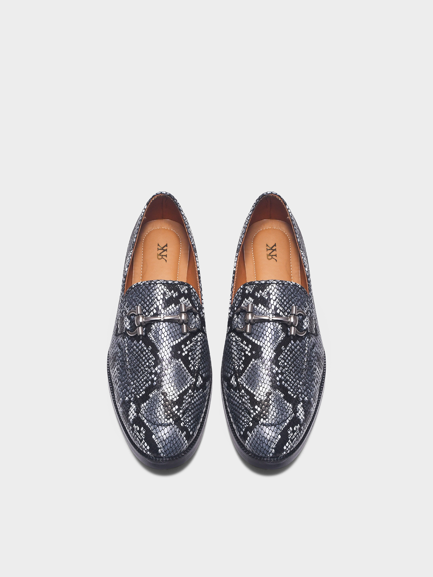 Pair of snake print horsebit loafers on a light gray background