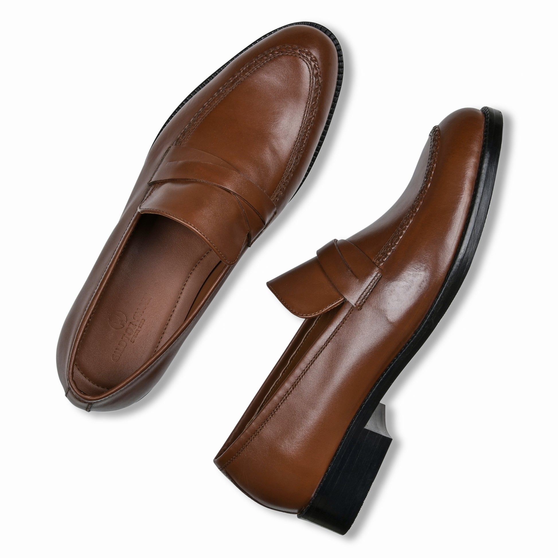 Pair of brown leather loafers on a white background