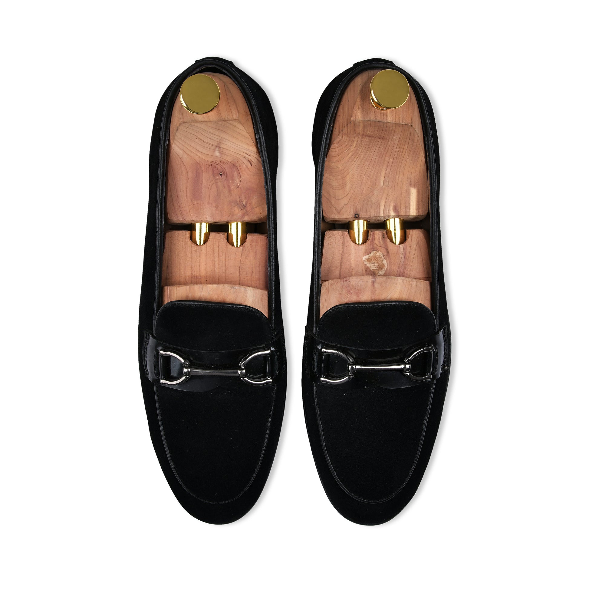Pair of black loafers with gold accents on a white background