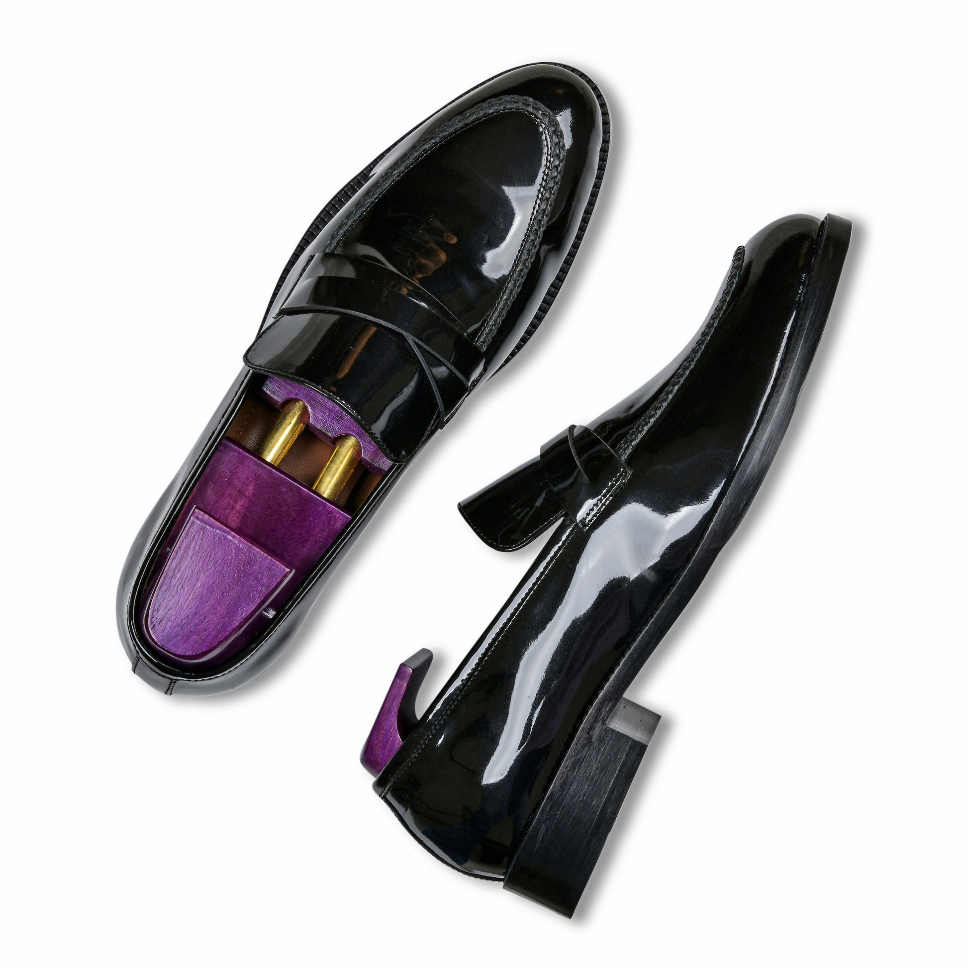 Black patent leather loafers with purple interior on a white background