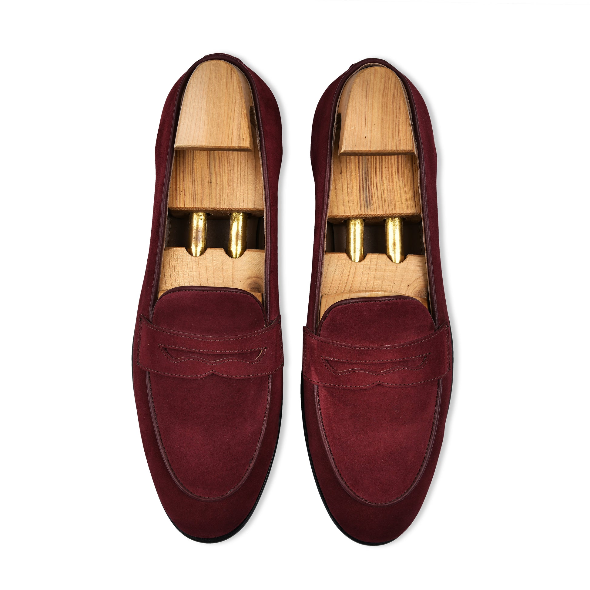 Pair of maroon loafers with wooden soles on a white background