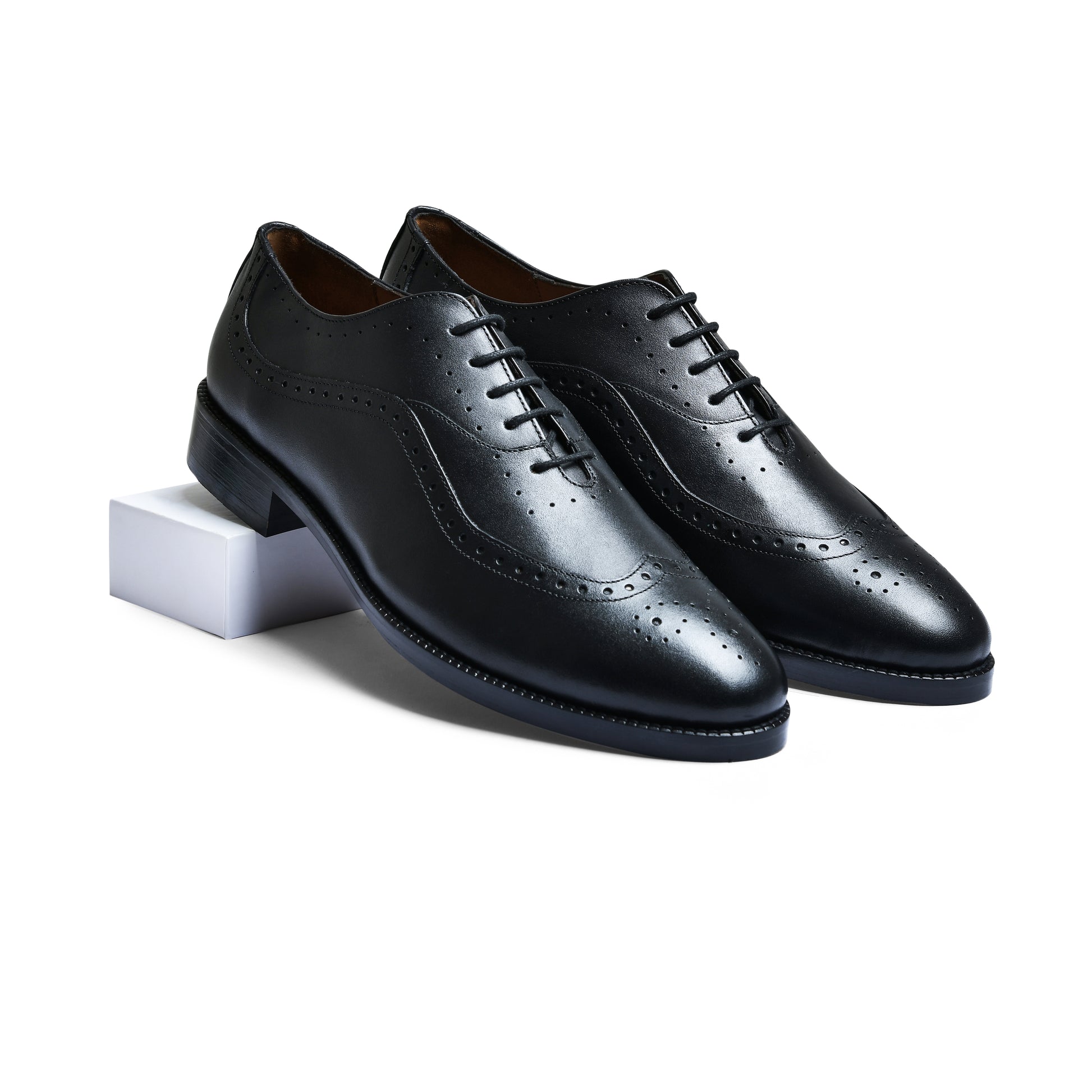 Pair of black leather dress shoes on a white background