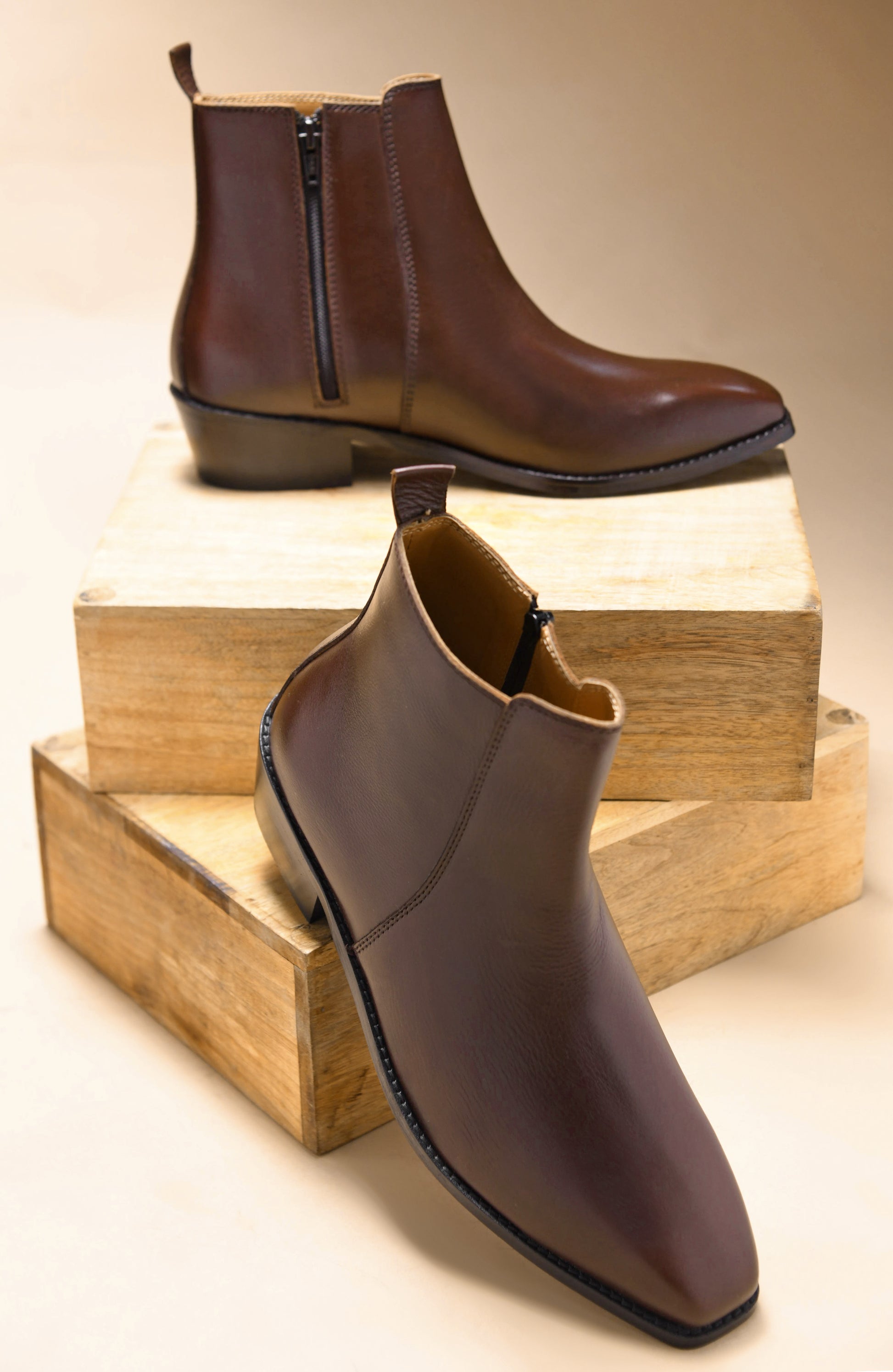 A brown, side zip leather boot with a cuban heel for men.