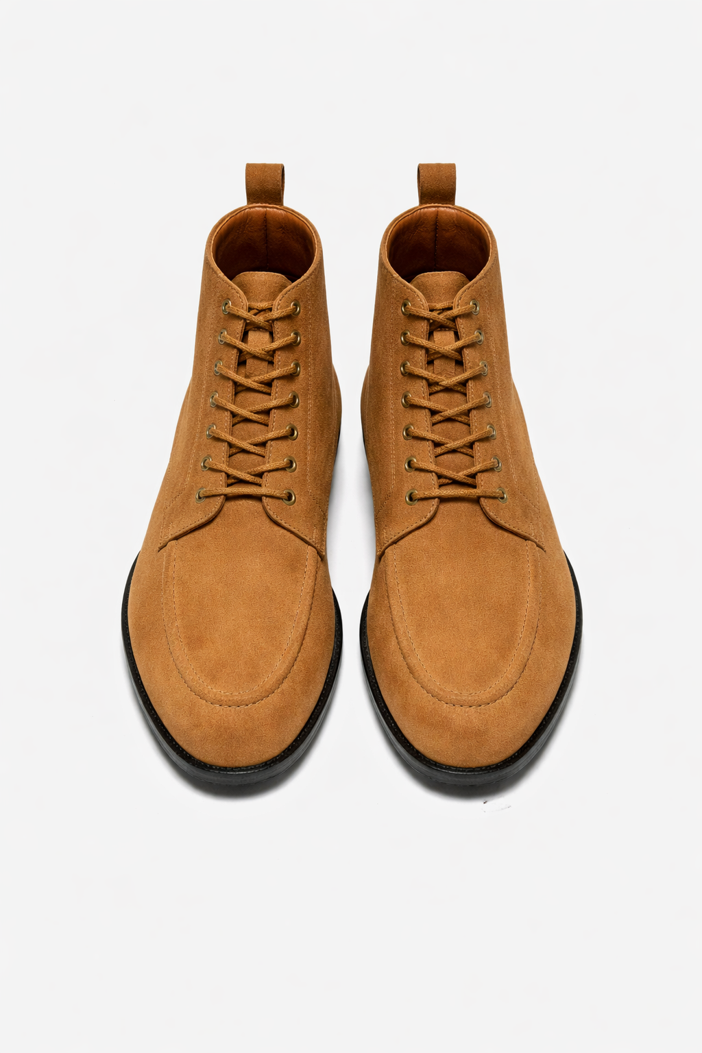 Pair of tan suede boots on a white background