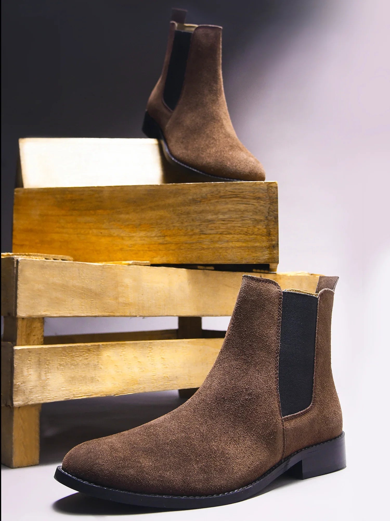 A men's luxury suede leather Chelsea boot with a mid heel and elastic side panels, in a brown color.