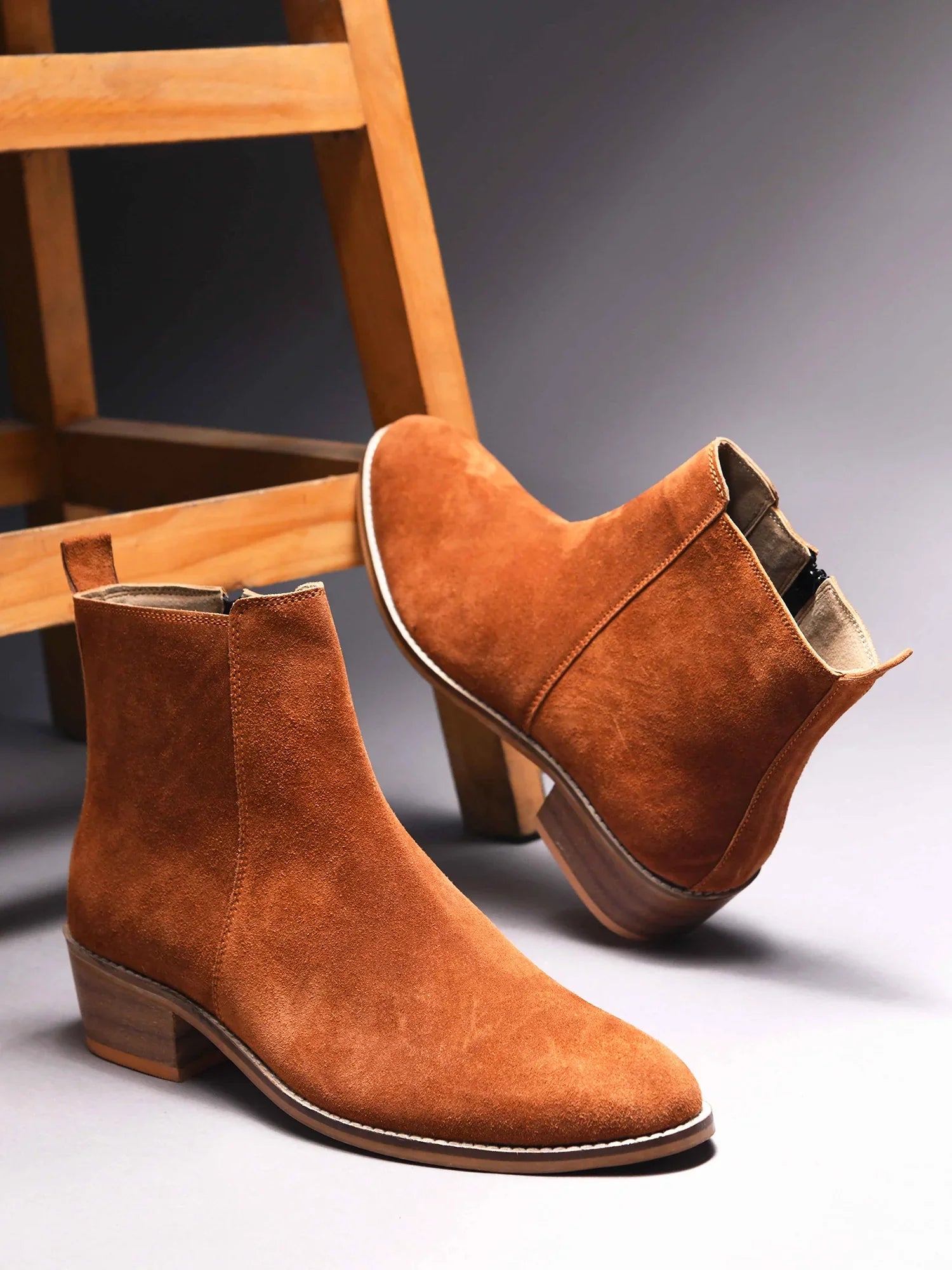 A men's luxury suede leather Chelsea boot with a cuban heel and zip side panels, in a tan color.