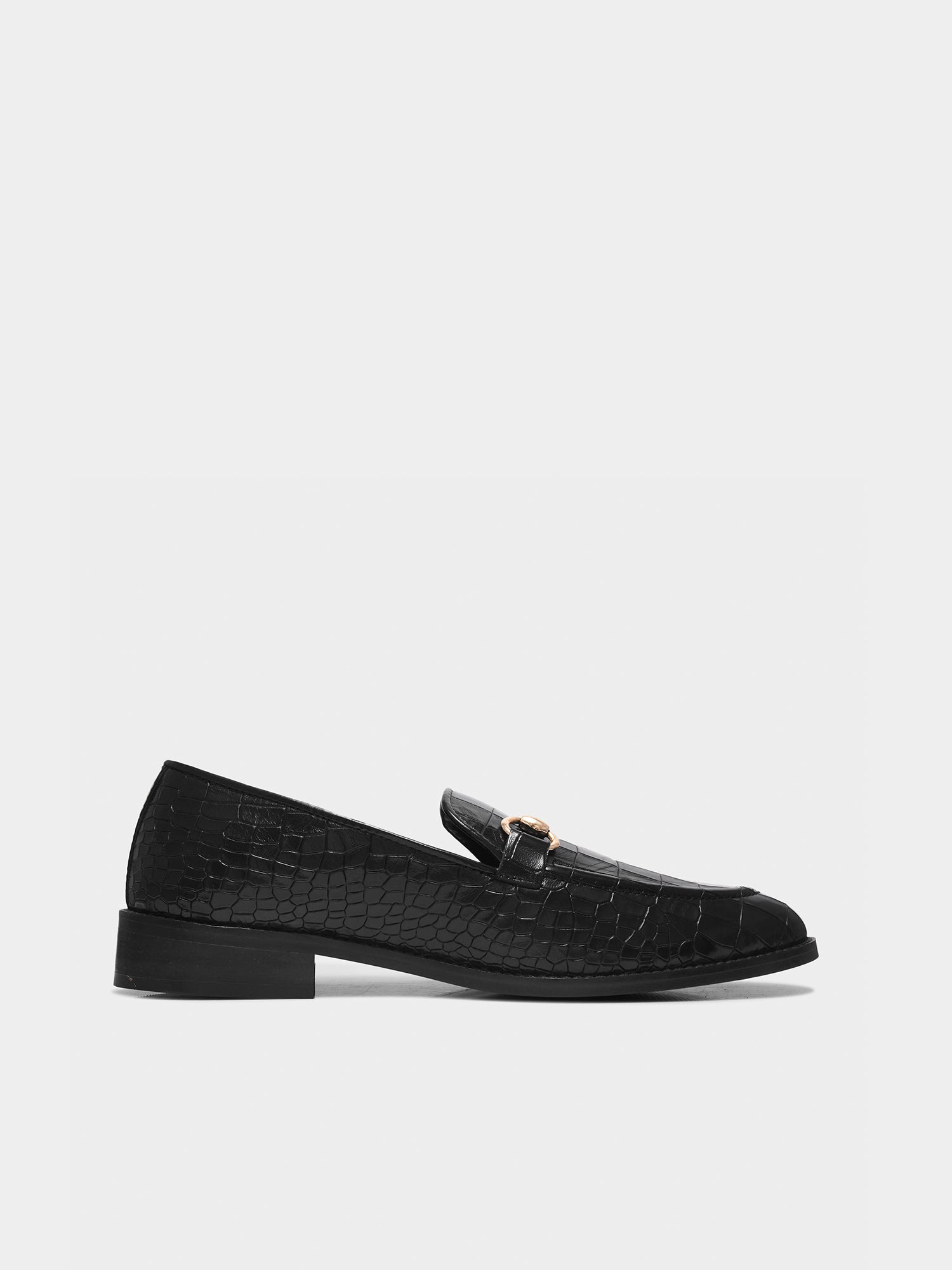 Black loafers with a textured pattern on a light gray background
