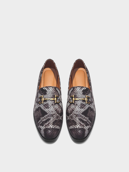 Pair of patterned loafers with gold accents on a light gray background