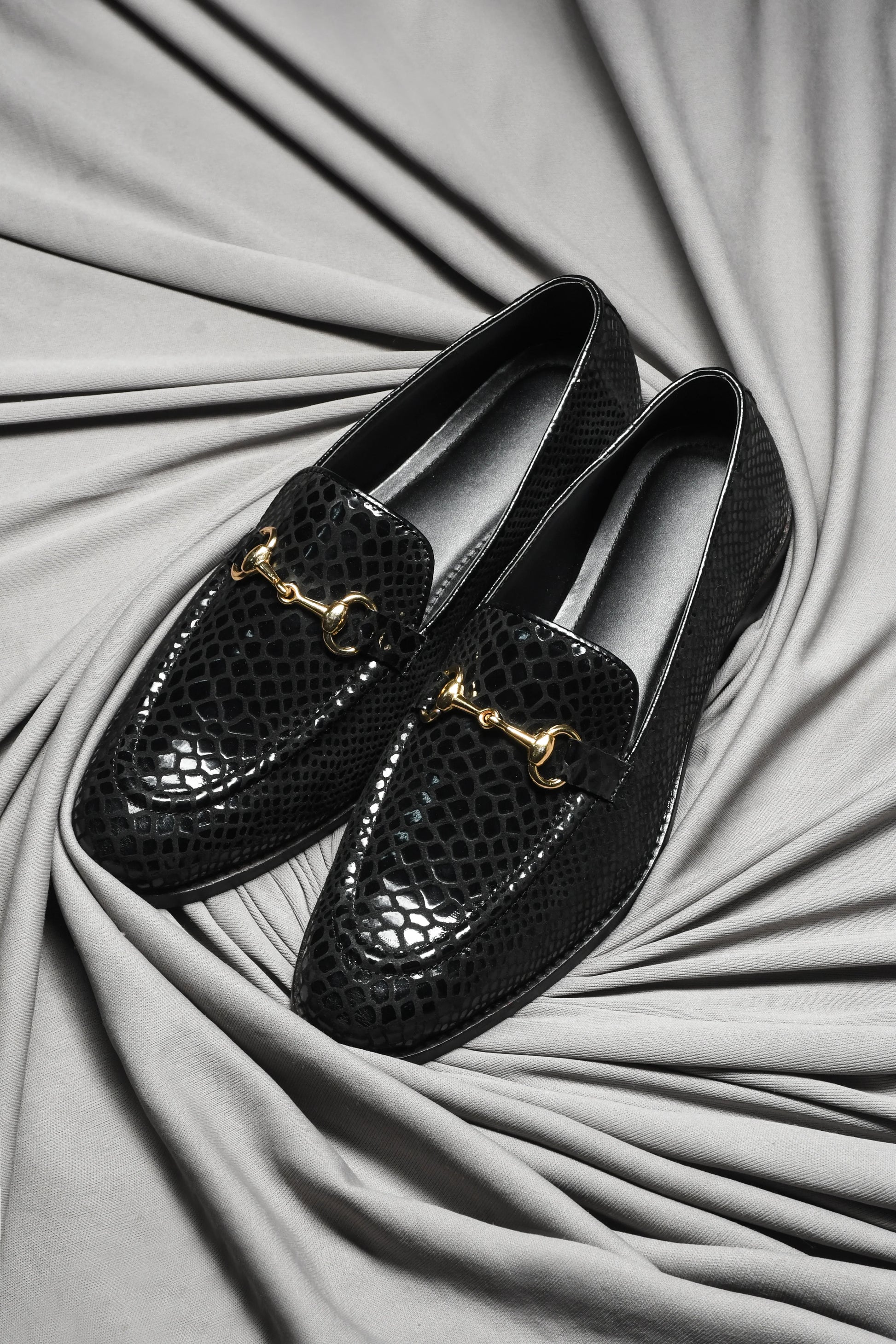 Pair of Black colour loafers with crocodile pattern and horsebit buckle in mid heel