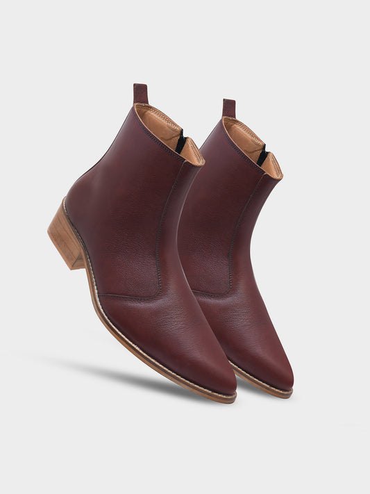 Pair of brown leather ankle boots on a light gray background