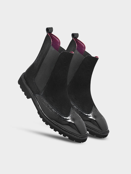 Black slip-on boots with purple lining on a light gray background