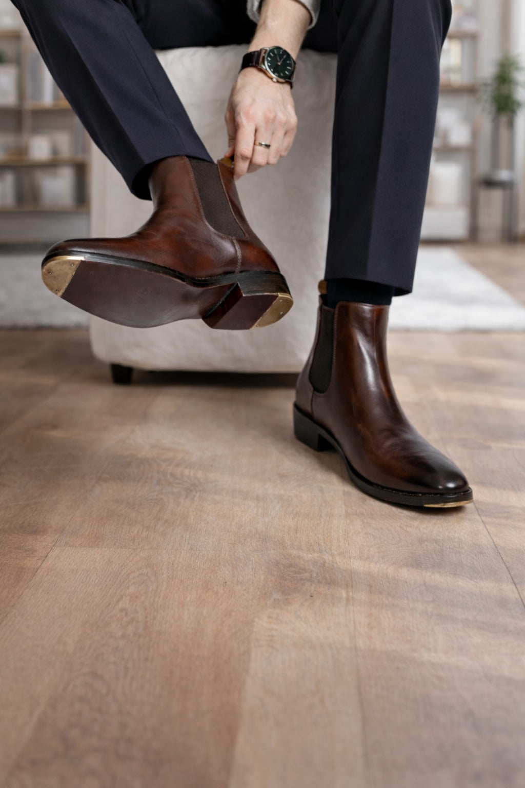 Person wearing brown leather boots on a wooden floor