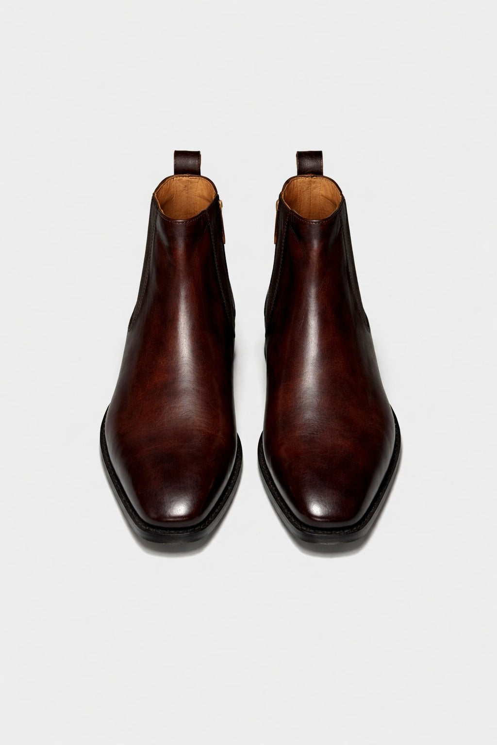 Pair of brown leather boots on a light gray background