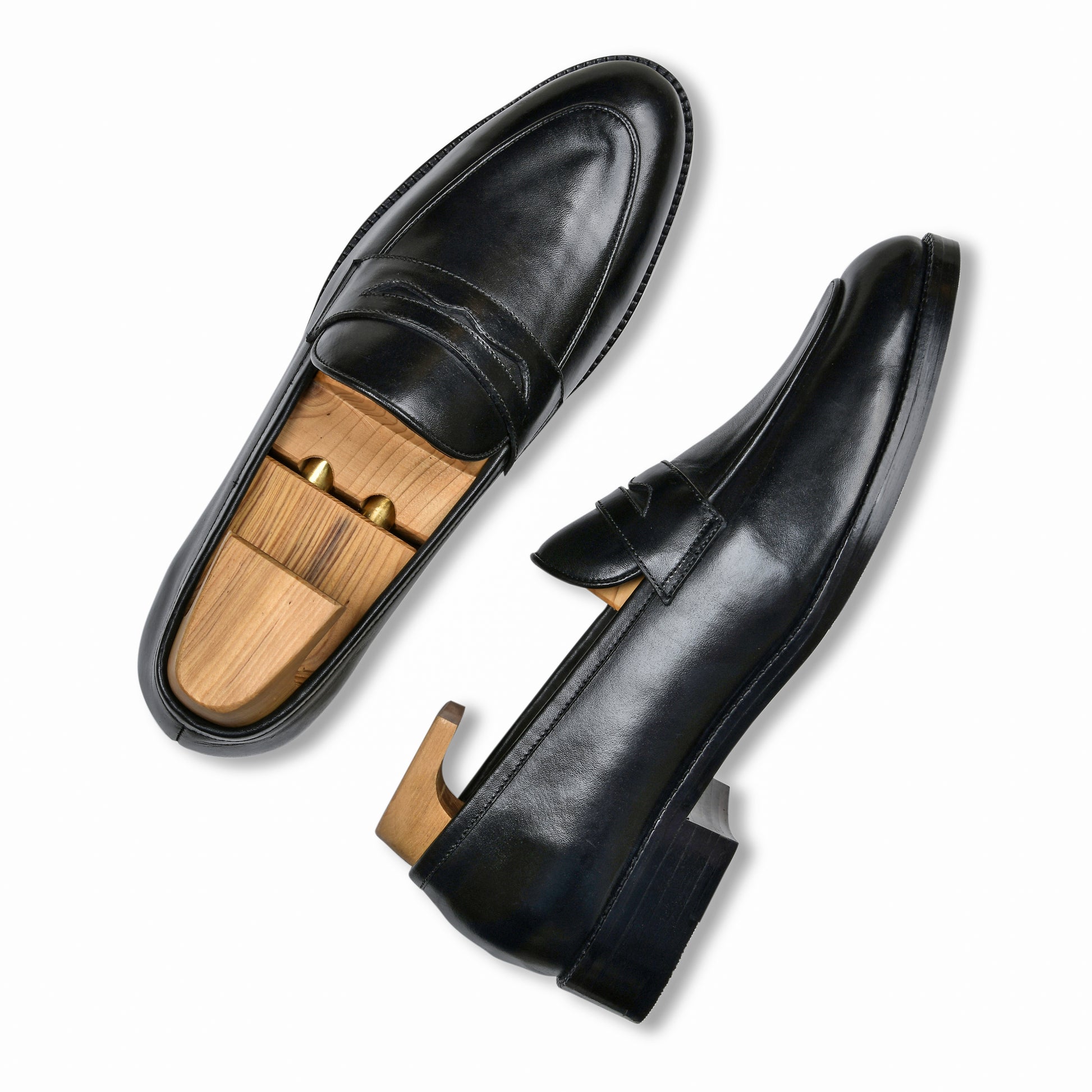 Black leather loafers with wooden insoles on a white background