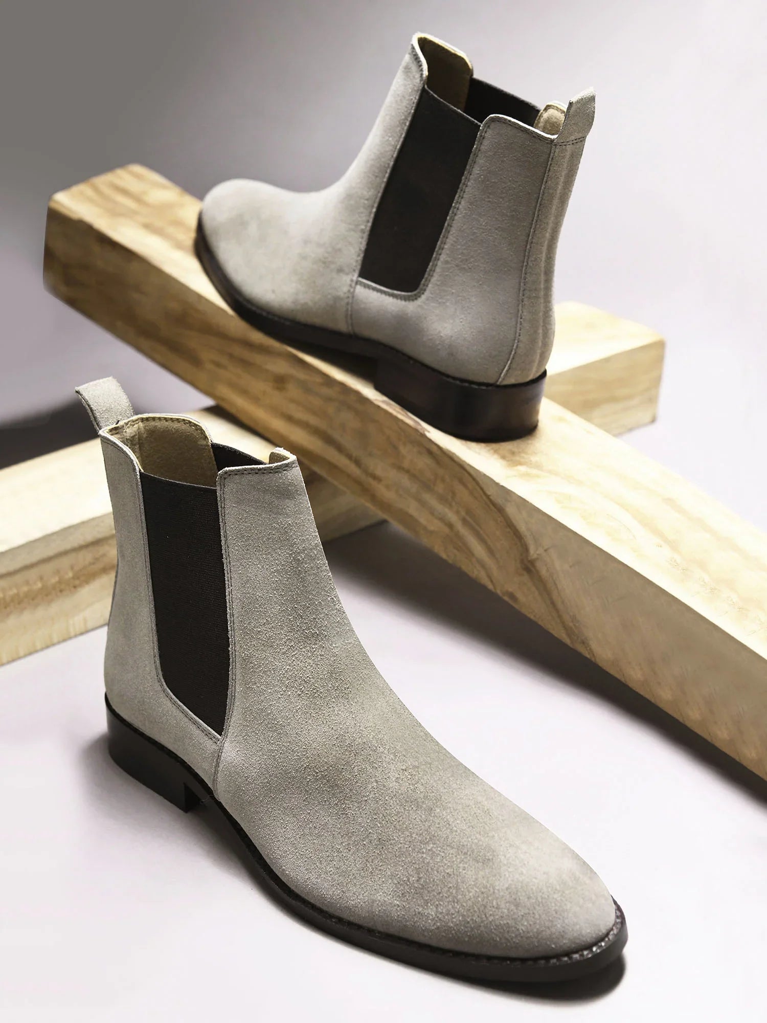 A men's luxury suede leather Chelsea boot with a cuban heel and elastic side panels, in a gray color.