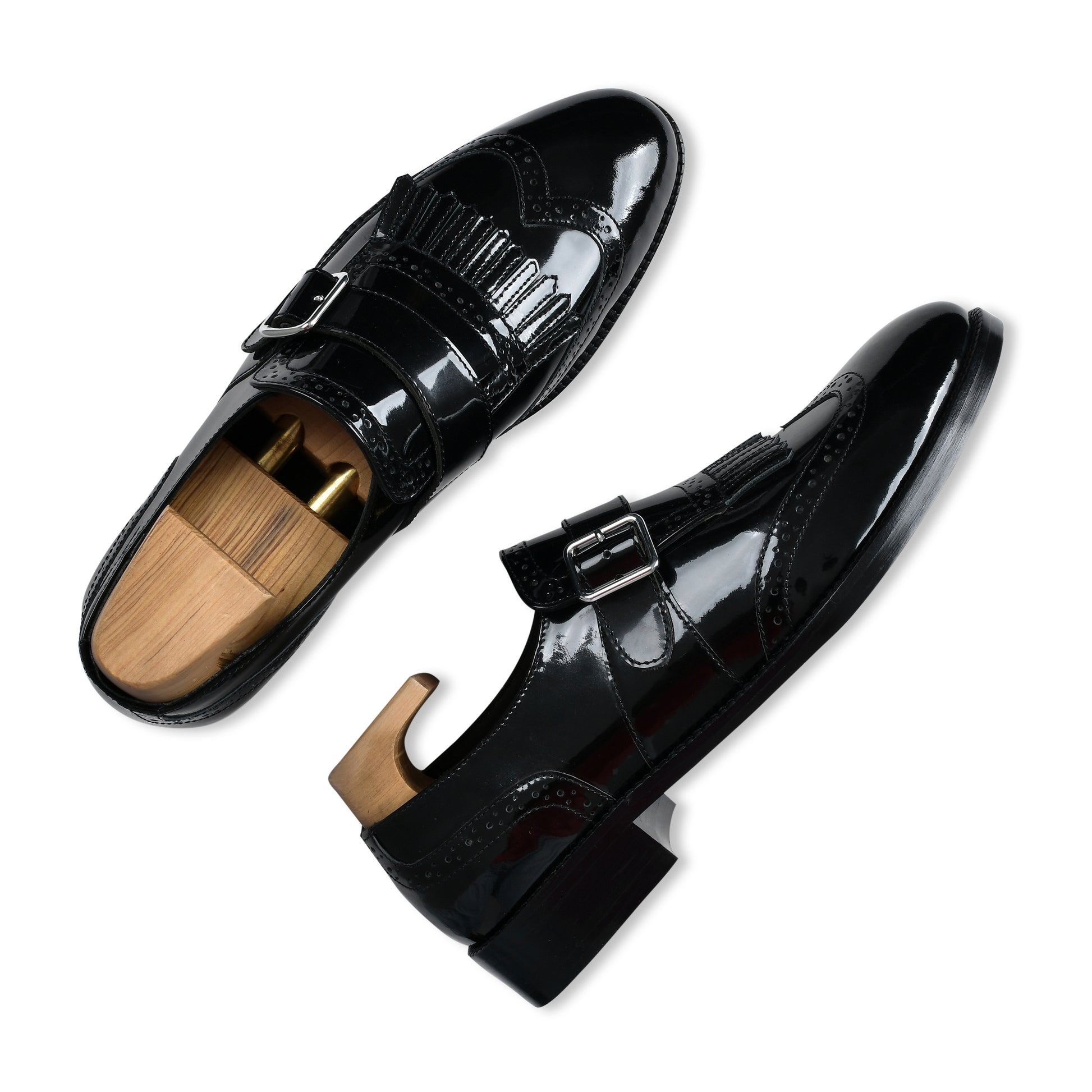 Black patent leather shoes with wooden soles on a white background