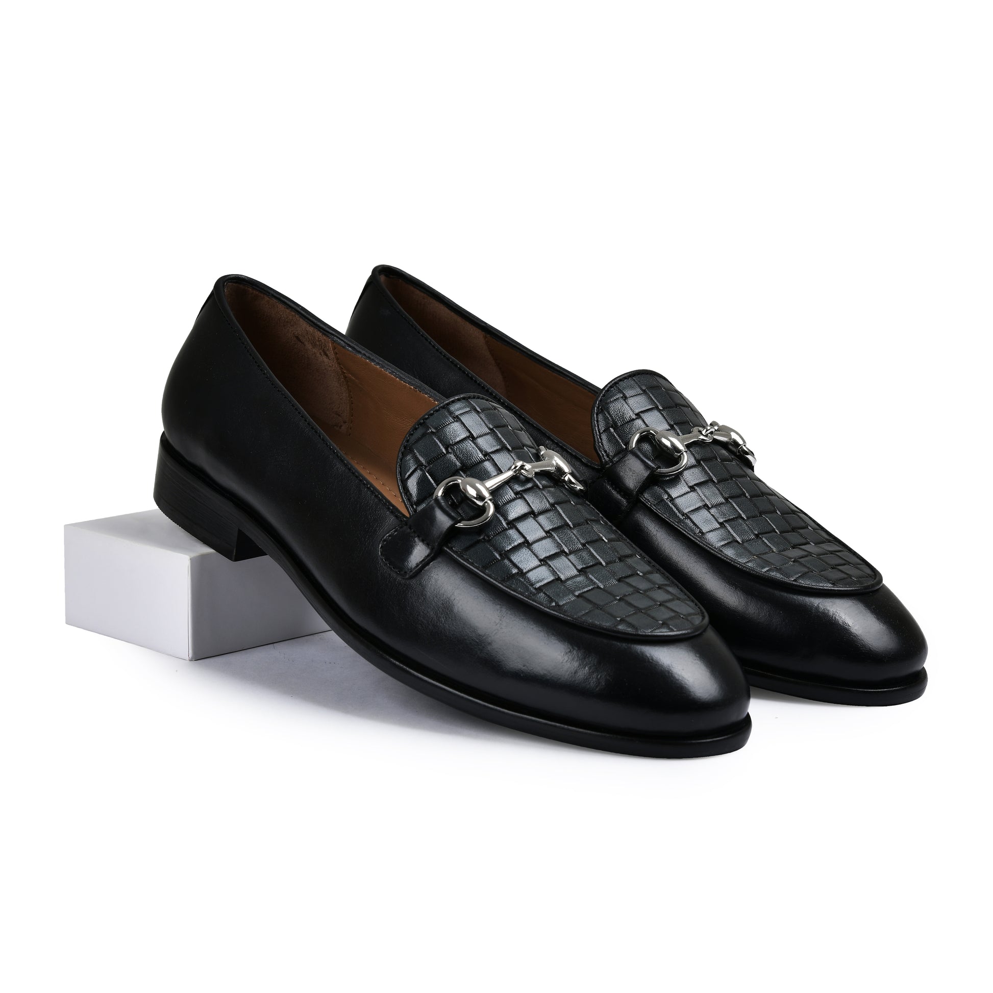 Pair of black leather loafers with woven detail on a white background