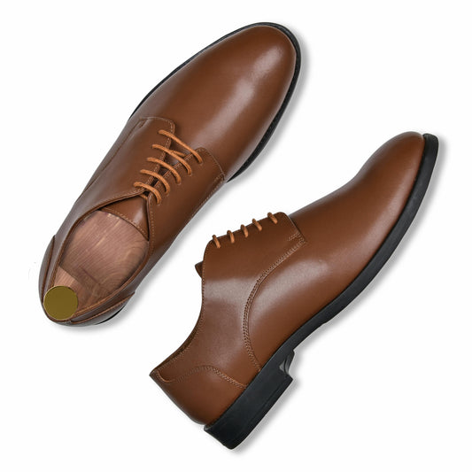 Pair of brown leather dress shoes on a white background