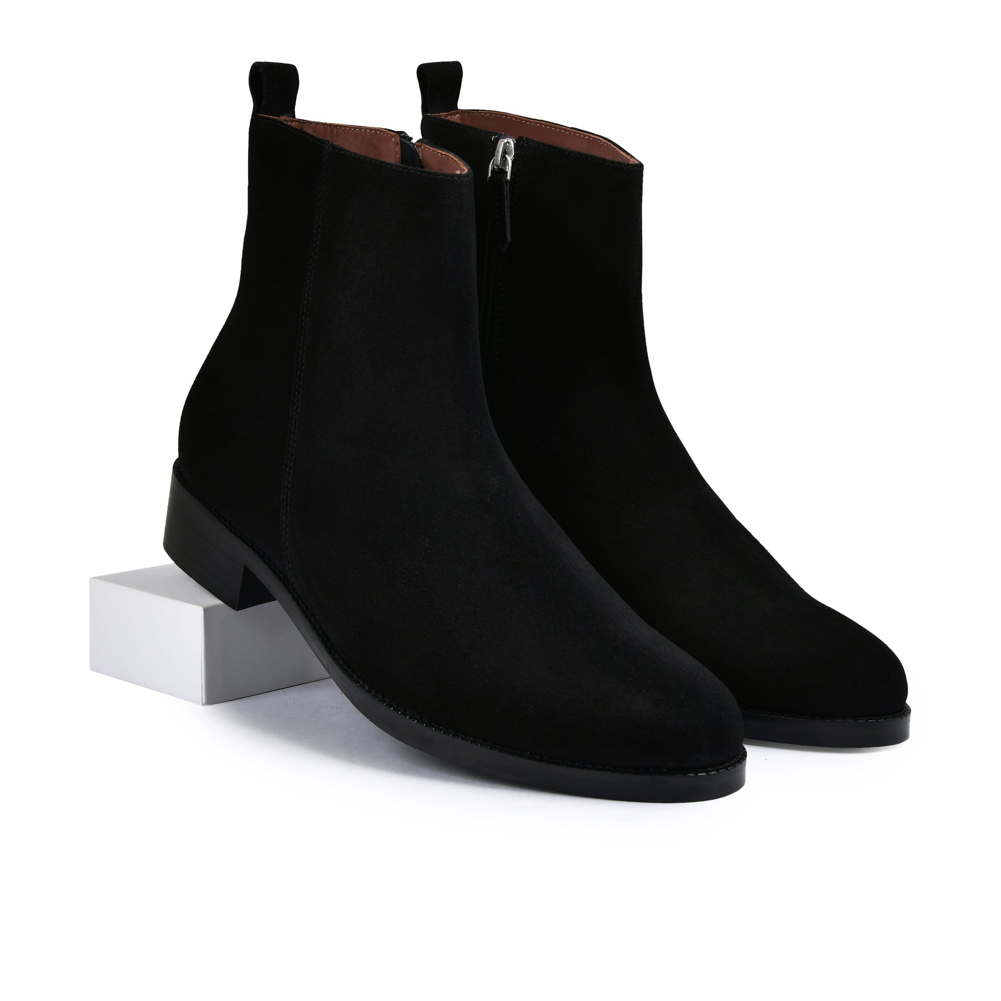 Pair of brown suede ankle boots on a white background