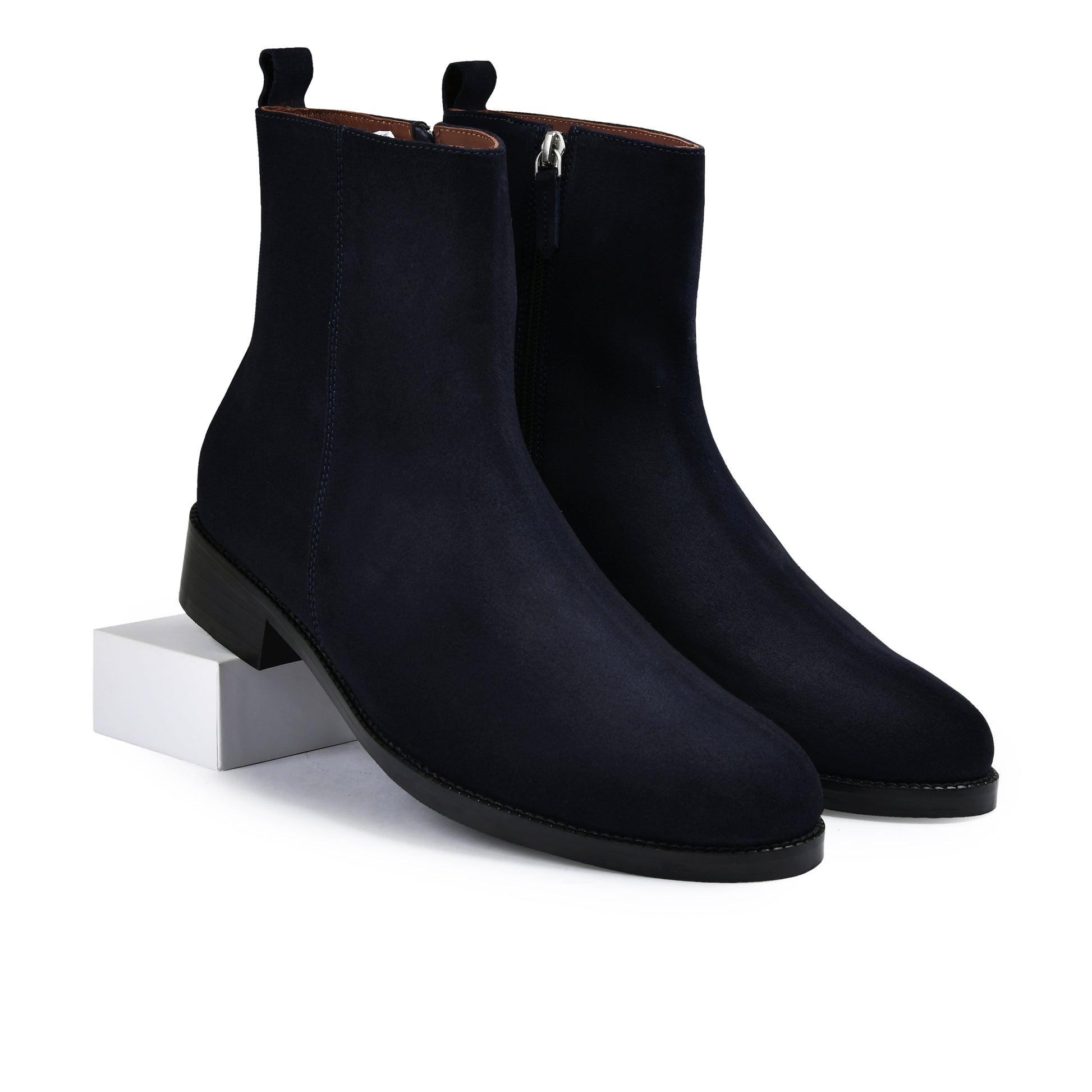 Pair of navy blue suede ankle boots on a white background