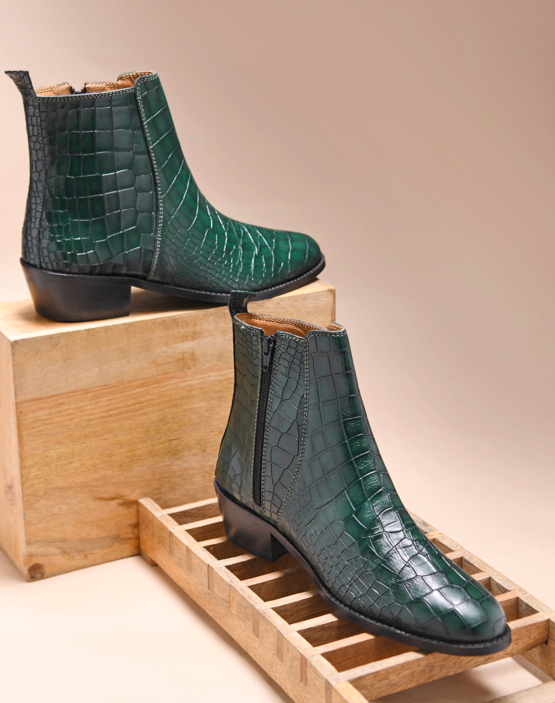 A green leather side zip boot with a crocodile pattern and a Cuban heel.