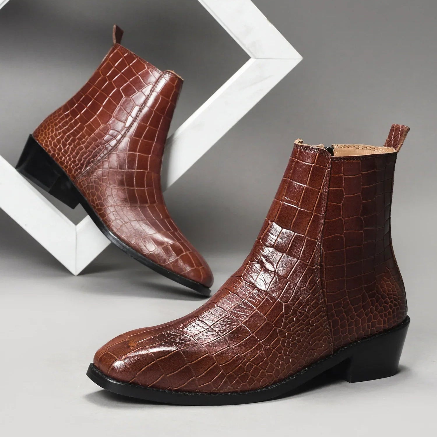 Pair of tan colour crocodile textured leather boots with side zip on a Cuban heel