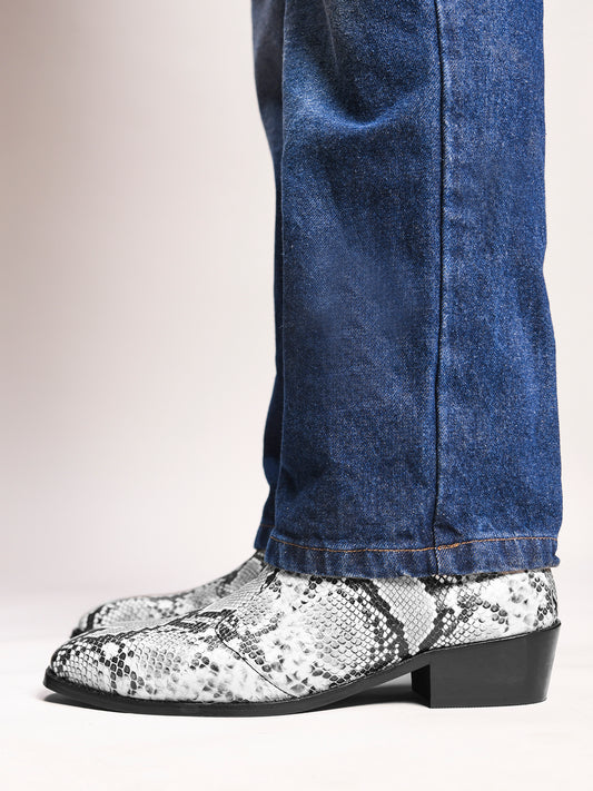 A pair of black and white snake printed leather boot with square toe and a black colour Cuban heel