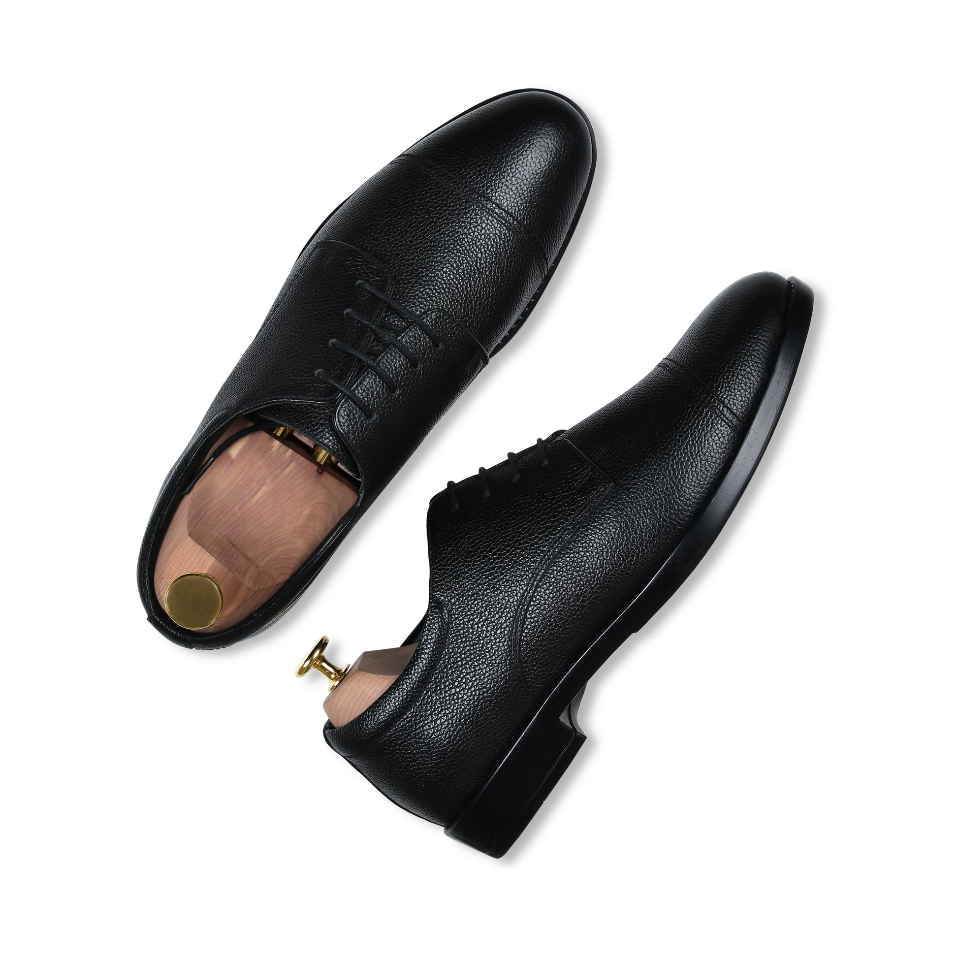 Pair of black leather dress shoes on a white background