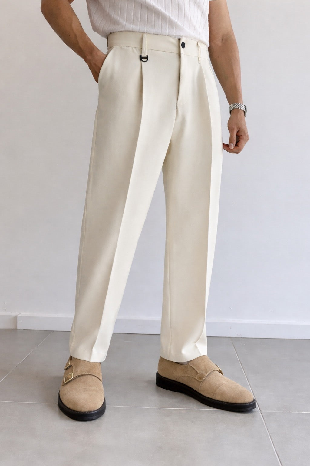 Person wearing beige pants and shoes on a plain background
