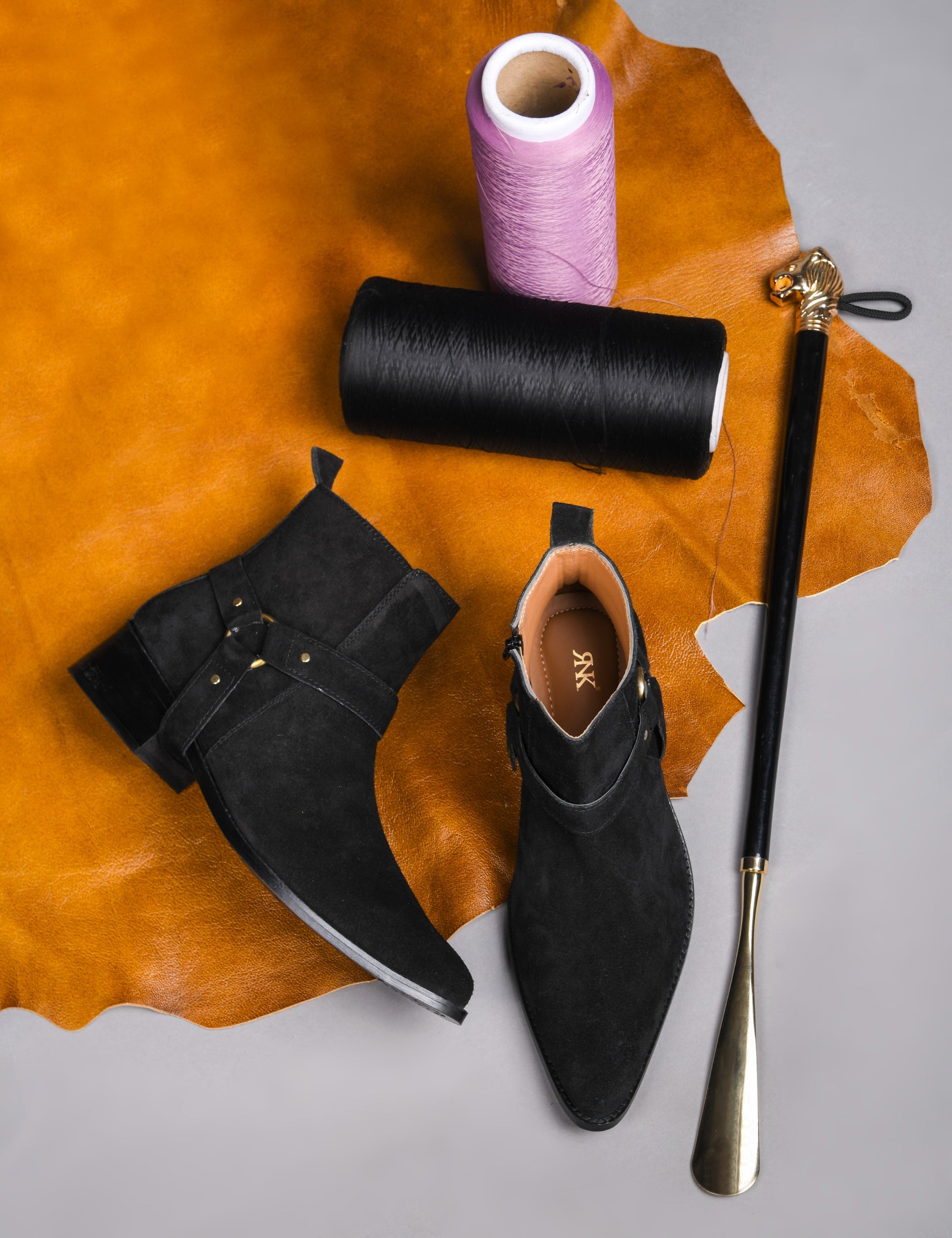 Phantom black suede harness boots for men featuring a pointed toe, side zip closure, and attached leather thong strap – luxury ankle boots by RNK Luxe for bold, stylish looks.