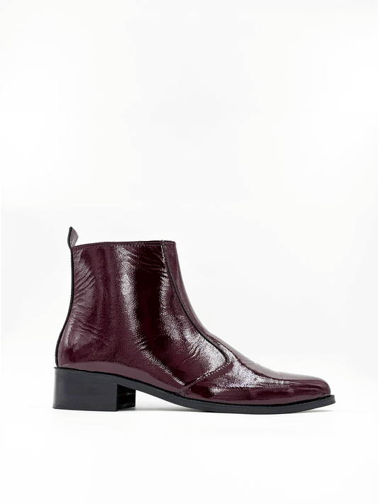 Men’s cherry red pointed-toe Chelsea boots in glossy patent leather with side zip closure, sleek and stylish luxury footwear ideal for formal and party outfits.