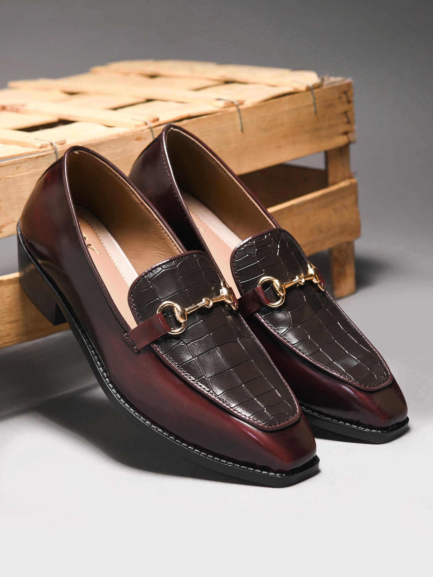 A pair of cherry leather loafer in which it embossed with brown croco leather on top with a golder horesit buckle