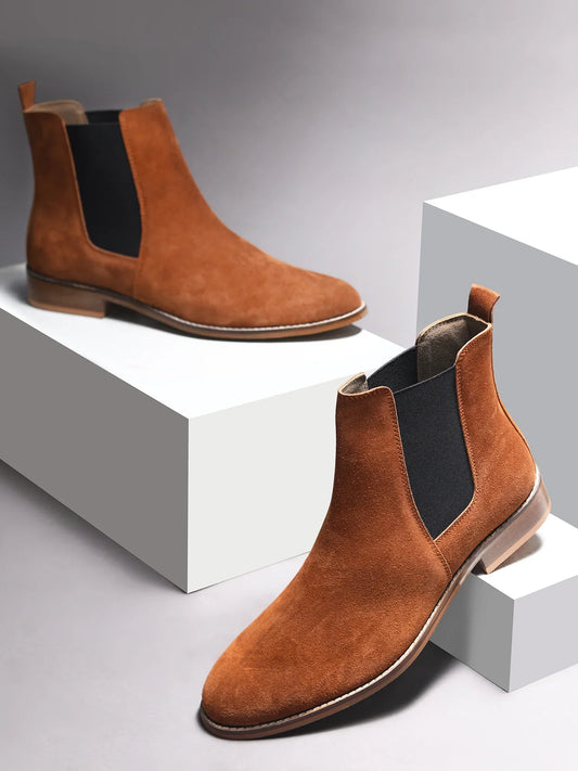 A men's luxury suede leather Chelsea boot with a mid heel and elastic side panels, in a tan color.