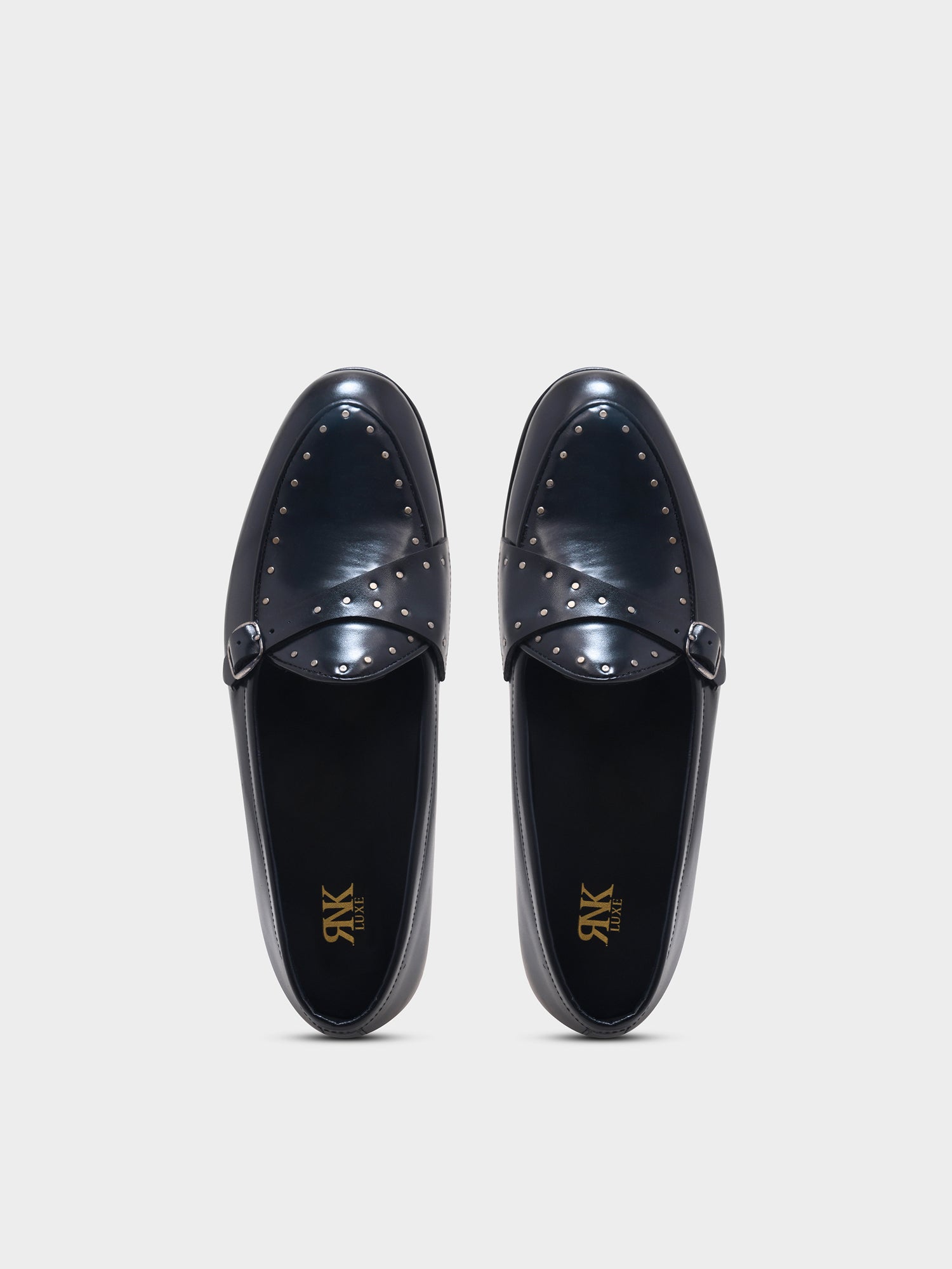 Pair of black loafers with studded details on a light gray background