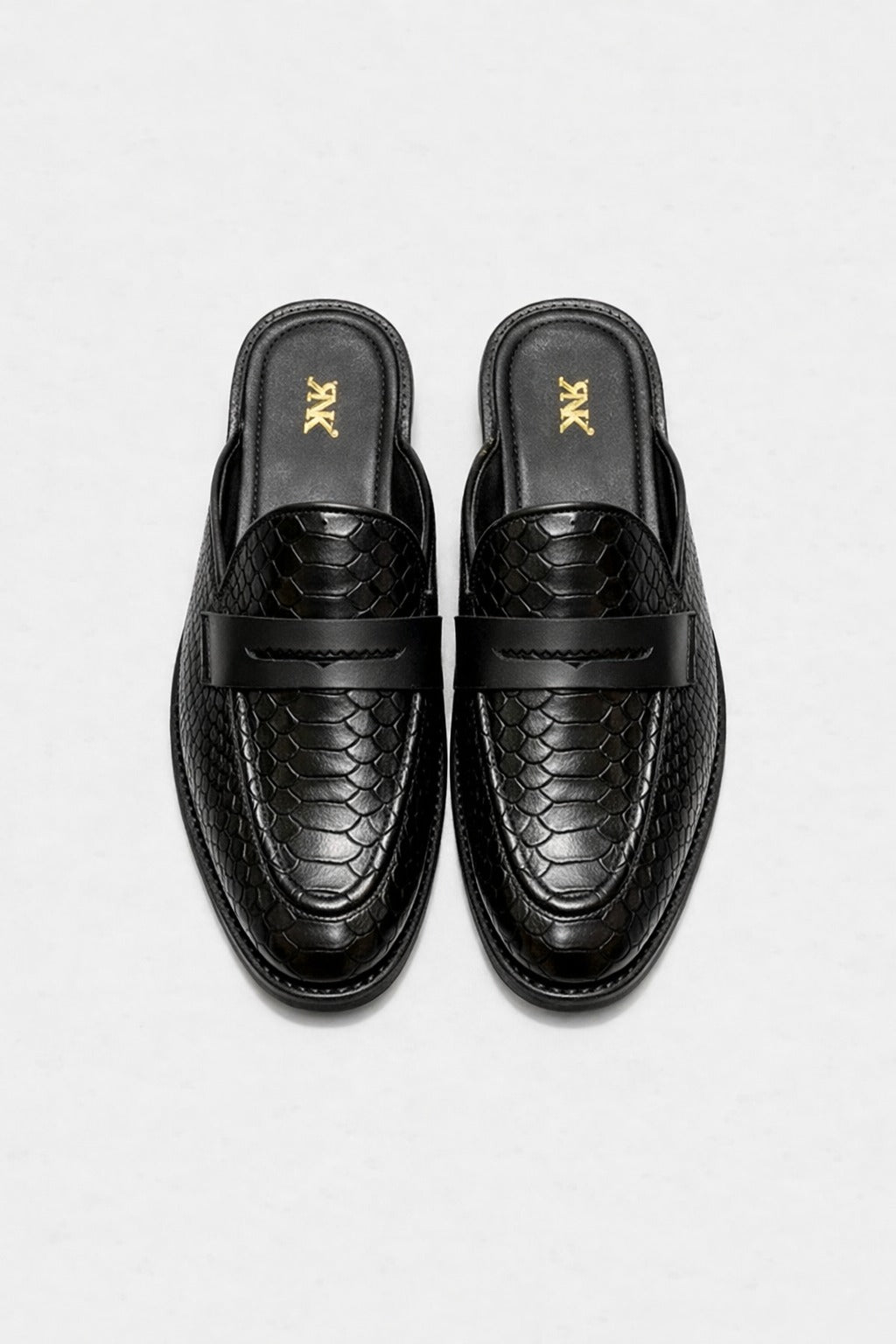 Pair of black loafers with snake skin pattern on a white background
