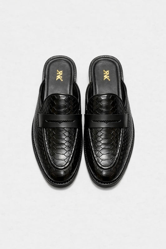Pair of black loafers with snake skin pattern on a white background