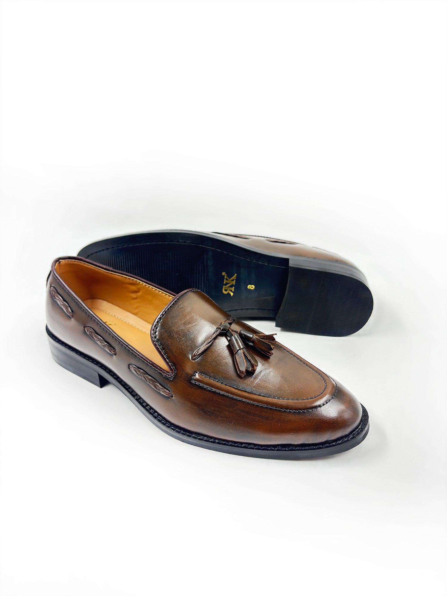 Brown leather loafer with tassel on a white background