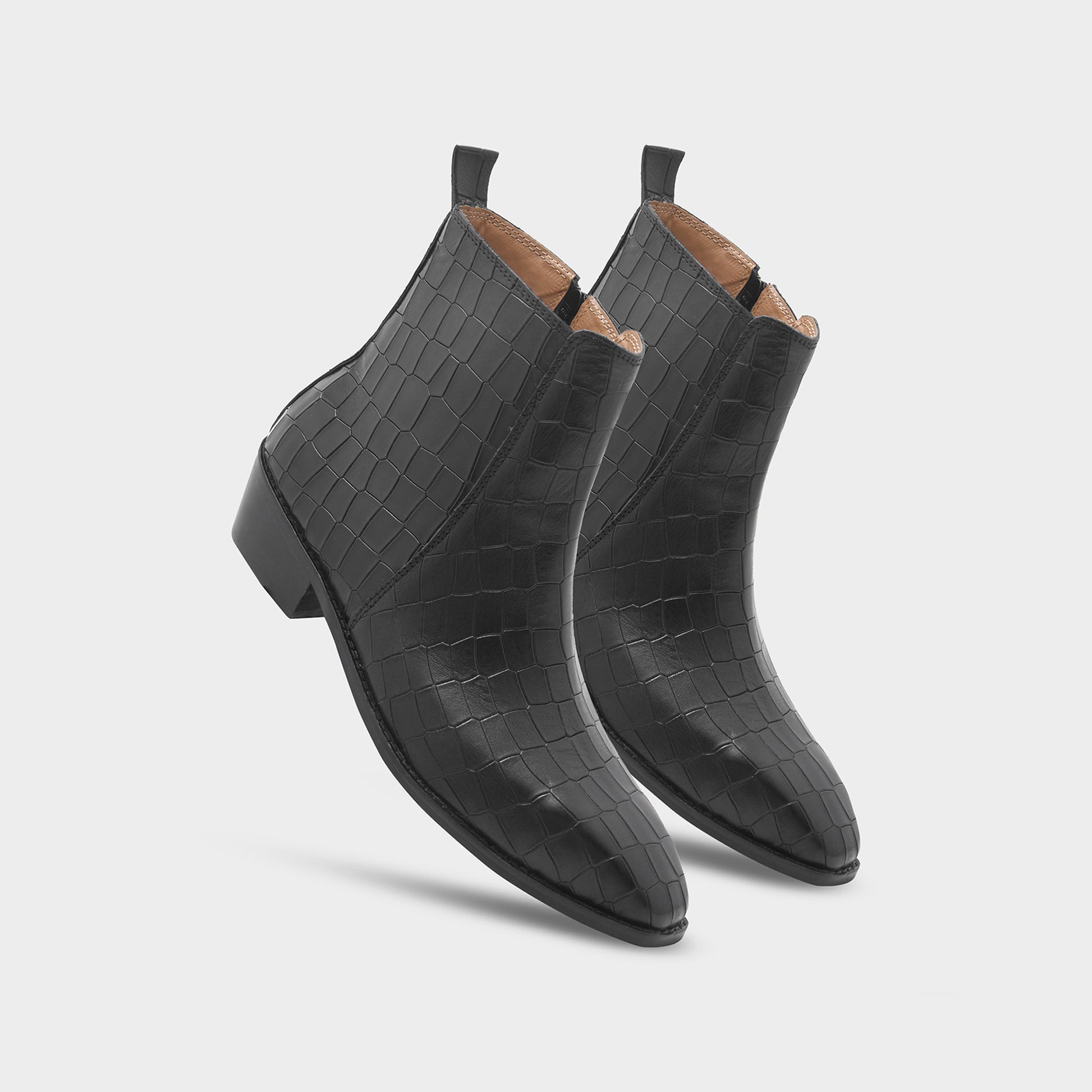 Pair of black crocodile-textured ankle boots on a light gray background
