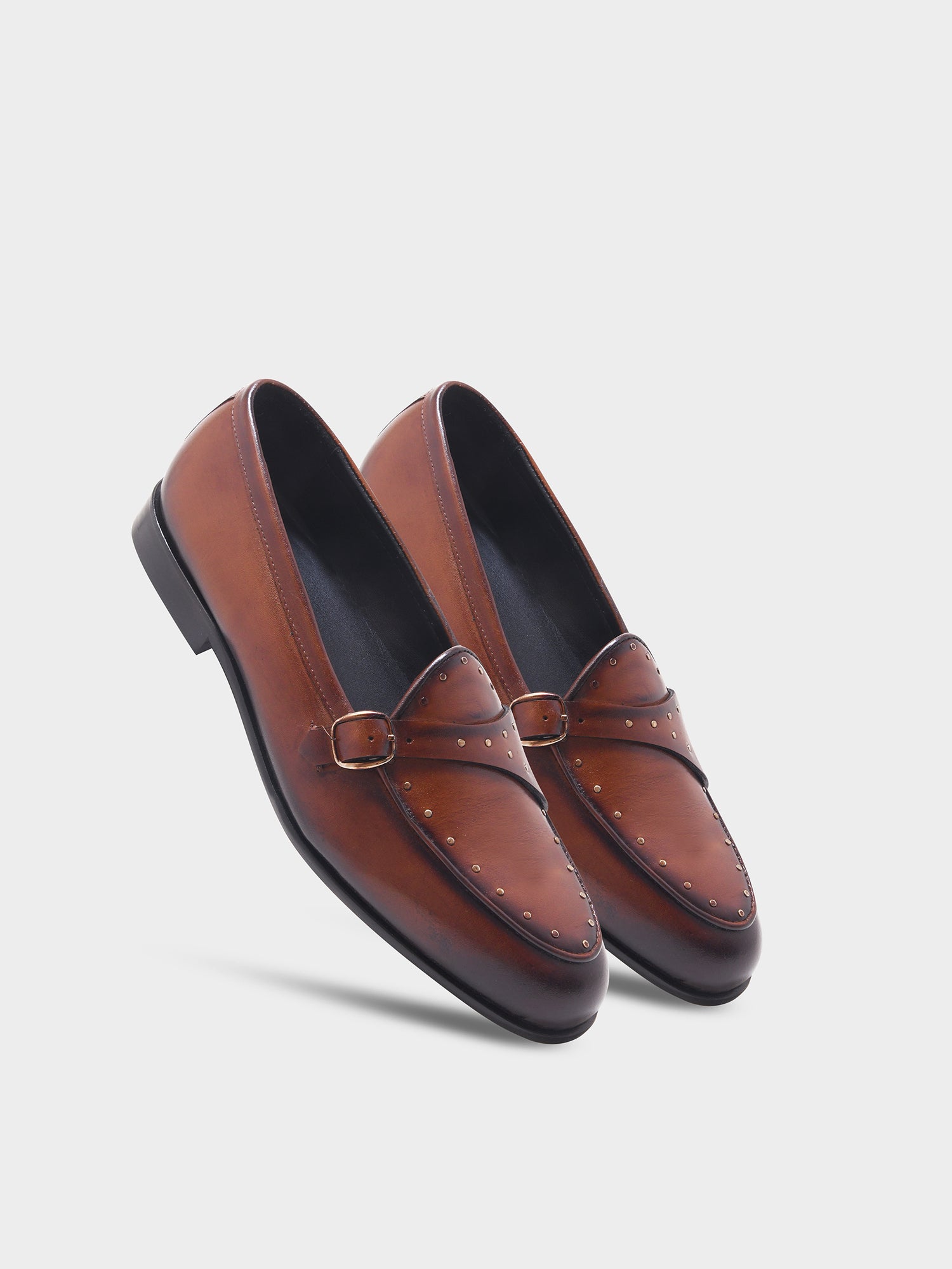 Pair of brown leather loafers on a light gray background